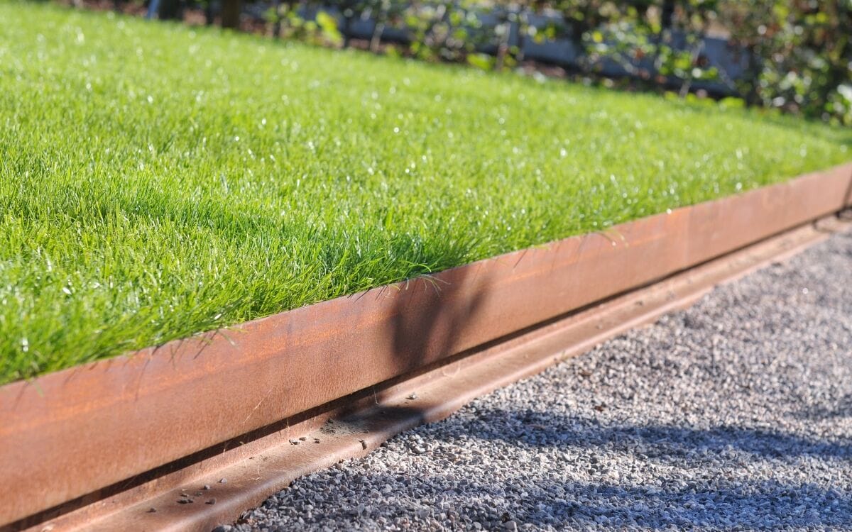Cortenstaal-borduur die gras van grind scheidt